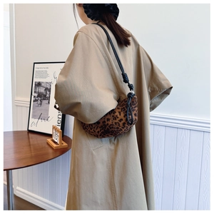 Close-up of leopard print shoulder bag featuring black knotted rope strap design