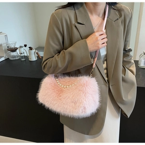 Detail of pink faux fur shoulder bag featuring elegant pearl handle and gold hardware