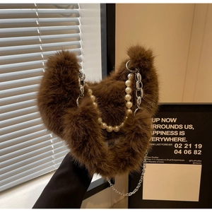 Détail du sac en peluche marron foncé avec chaîne de perles blanches et maillons argentés