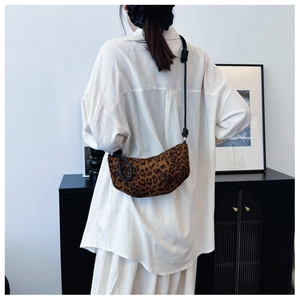 Detail of leopard print crescent bag with adjustable knotted strap on a model