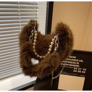 Gros plan d'un sac à main en peluche marron avec perles et chaîne en métal argenté