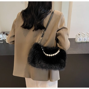 Detail of black faux fur shoulder bag featuring elegant pearl chain and soft texture