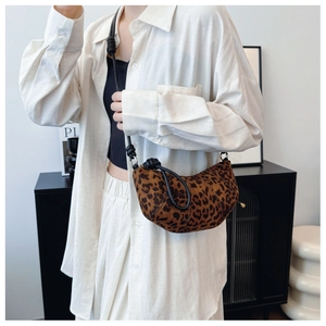 Detail of leopard print half-moon bag with black leather knotted strap and canvas texture