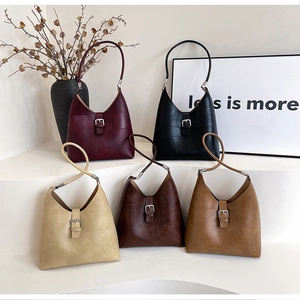 Detailed display of vintage underarm bags in five colors on a minimalist display stand