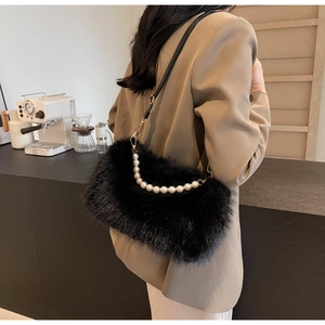 Detail of soft black faux fur shoulder bag with pearl handle and leather strap