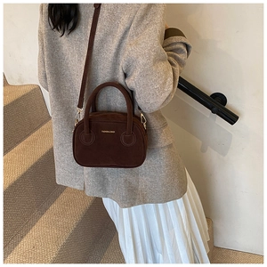 Détail du sac à bandoulière en daim marron avec lettrage doré Fashion & Bags