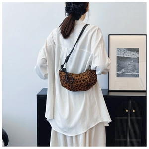 Detail of leopard print crescent crossbody bag styled with white shirt and black strap