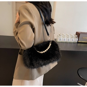 Detail of black faux fur shoulder bag featuring elegant pearl chain and soft plush texture