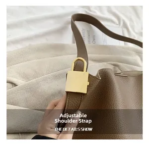 Detail of brown leather tote bag with adjustable strap and golden square buckle