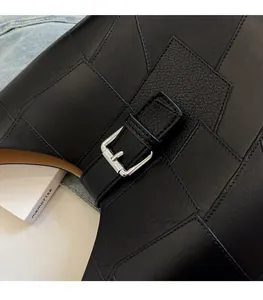 Close-up of black pebble grain PU leather tote bag with silver buckle and inner pouch