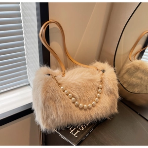 Detail view of plush beige shoulder bag with pearl chain strap and fuzzy texture