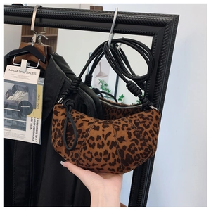Detail shot of leopard print crescent bag with distinctive knotted shoulder strap texture