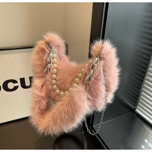 Détail du sac à bandoulière rose en peluche avec bandoulière perle et chaîne argentée
