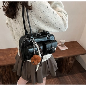 Détail du sac à épaule en cuir PU noir avec poches cargo et breloque ours en peluche