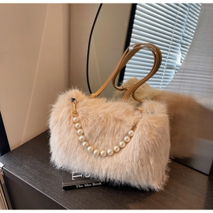 Detail of beige faux fur shoulder bag featuring decorative pearl chain and slim strap