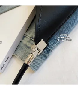 Detail of silver polished metal hardware on a black smooth leather shoulder bag