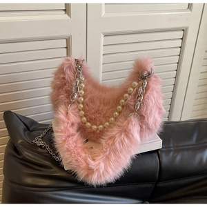 Détail du sac à main cœur en fausse fourrure rose avec chaîne argentée et perles