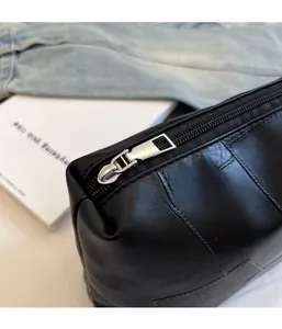 Detail of silver zipper and lychee grain leather on black vintage underarm bag