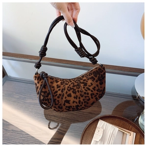 Detail of leopard print croissant bag with knotted shoulder strap and crescent shape