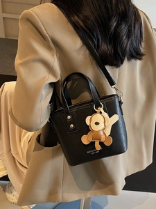Modische schwarze Leder-Eimertasche mit Kontrast-Logo und niedlichem Affen-Anhang
