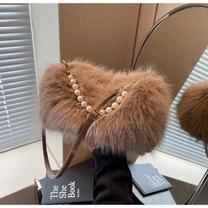 Detail of brown faux fur handbag with elegant white pearl strap and leather handle