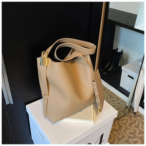 Close-up of khaki tote bag with lychee texture leather and a gold lock detail