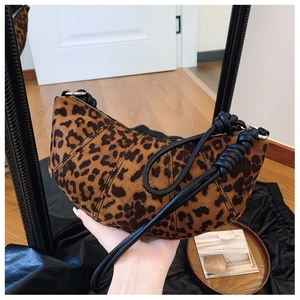 Detail of leopard print croissant bag showing knotted strap and textured fabric