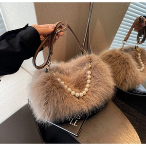 Detail of fluffy faux fur bag featuring pearl top handle and adjustable leather strap