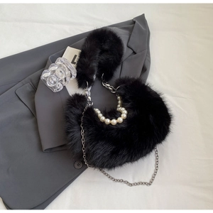 Détail du sac en fausse fourrure noire avec poignée en perles et chaîne argentée