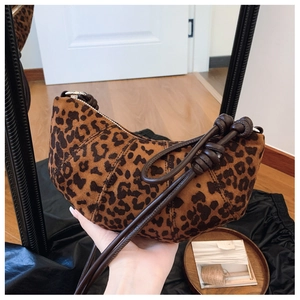 Detail of leopard print suede croissant bag showing knotted strap and velvet texture