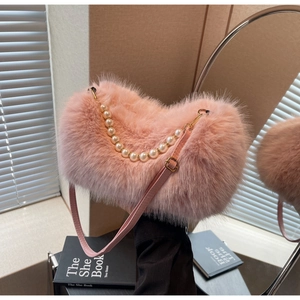 Close-up of pink faux fur texture with large pearl handle and gold hardware on bag