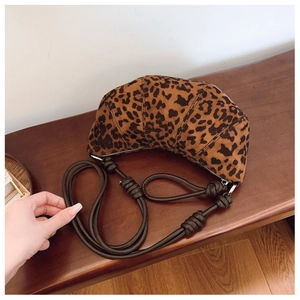 Close-up of leopard print dumpling bag with dark brown knotted rope shoulder strap