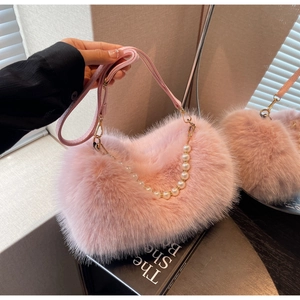 Macro detail of plush pink bag showing soft faux fur texture and elegant pearl chain handle