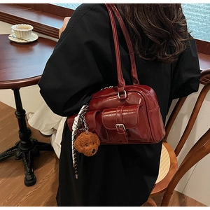 Vue détaillée du sac bowling rétro bordeaux avec breloque ours en peluche et foulard en soie