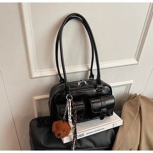 Détail du sac à bandoulière noir brillant avec poches et pendentif ours mignon