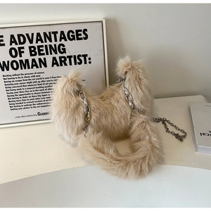 Détail d'un sac d'épaule en fausse fourrure avec grosse chaîne en métal argenté blanc crème