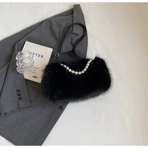 Detail of black faux fur shoulder bag with pearl handle and golden metal buckles