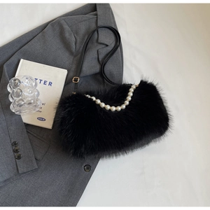 Flat lay of black faux fur shoulder bag with pearl chain and leather strap