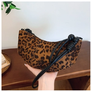 Detailed macro of leopard print suede croissant bag with knotted black handle detail