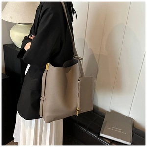 Close-up of litchi texture brown leather tote bag with small zipper pouch and gold hardware