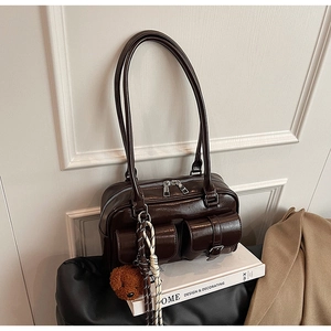 Détail du sac sous l'aisselle en cuir PU marron foncé avec boucles et breloque ours