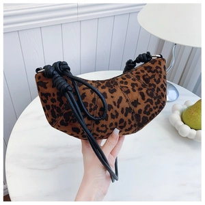 Detail of leopard print suede crescent bag with black leather knotted strap