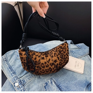 Detail of leopard print half-moon bag featuring black woven rope shoulder strap