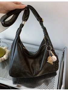 Fashionable black leather hobo bag with large capacity and baseball pendant charm