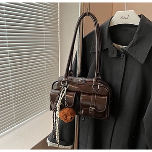 Détail du sac oreiller marron foncé brillant avec poches à rabat et boucles argentées
