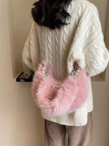 Sac bandoulière en fausse fourrure rose avec chaîne argentée et perles sur modèle