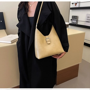 Close-up of beige matte leather shoulder bag with square stitching and buckle detail