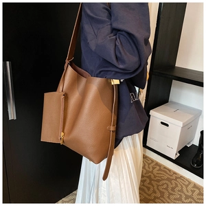 Detail of brown litchi pattern leather bucket bag with wide strap and matching pouch