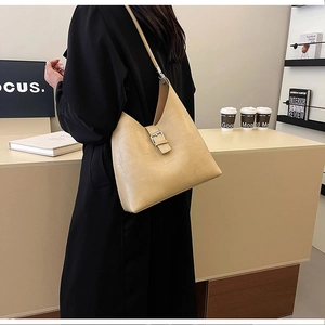 Detail of beige hobo bag with geometric texture, adjustable strap and silver buckle closure