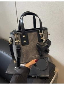 Chic grey denim mini bucket bag with black leather trim and cute puppy charm accessory
